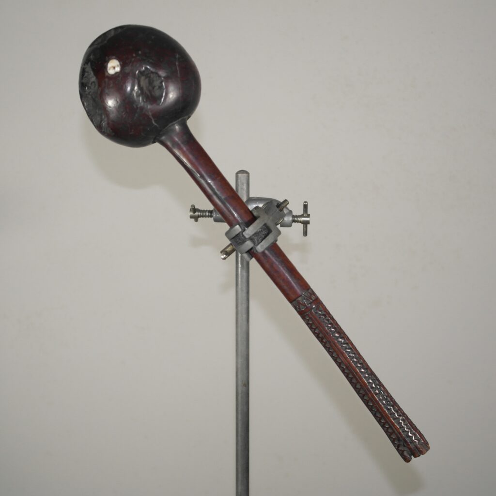 Early 19th century Fijian ula throwing club with a single human tooth inset and tavatava carving to the handle. This club has three suspension holes to the handle all of which have broken through.
