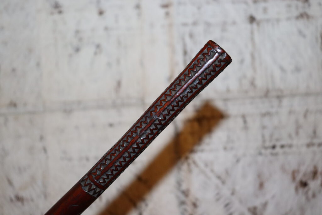 Early 19th century Fijian ula throwing club with a single human tooth inset and tavatava carving to the handle. This club has three suspension holes to the handle all of which have broken through.