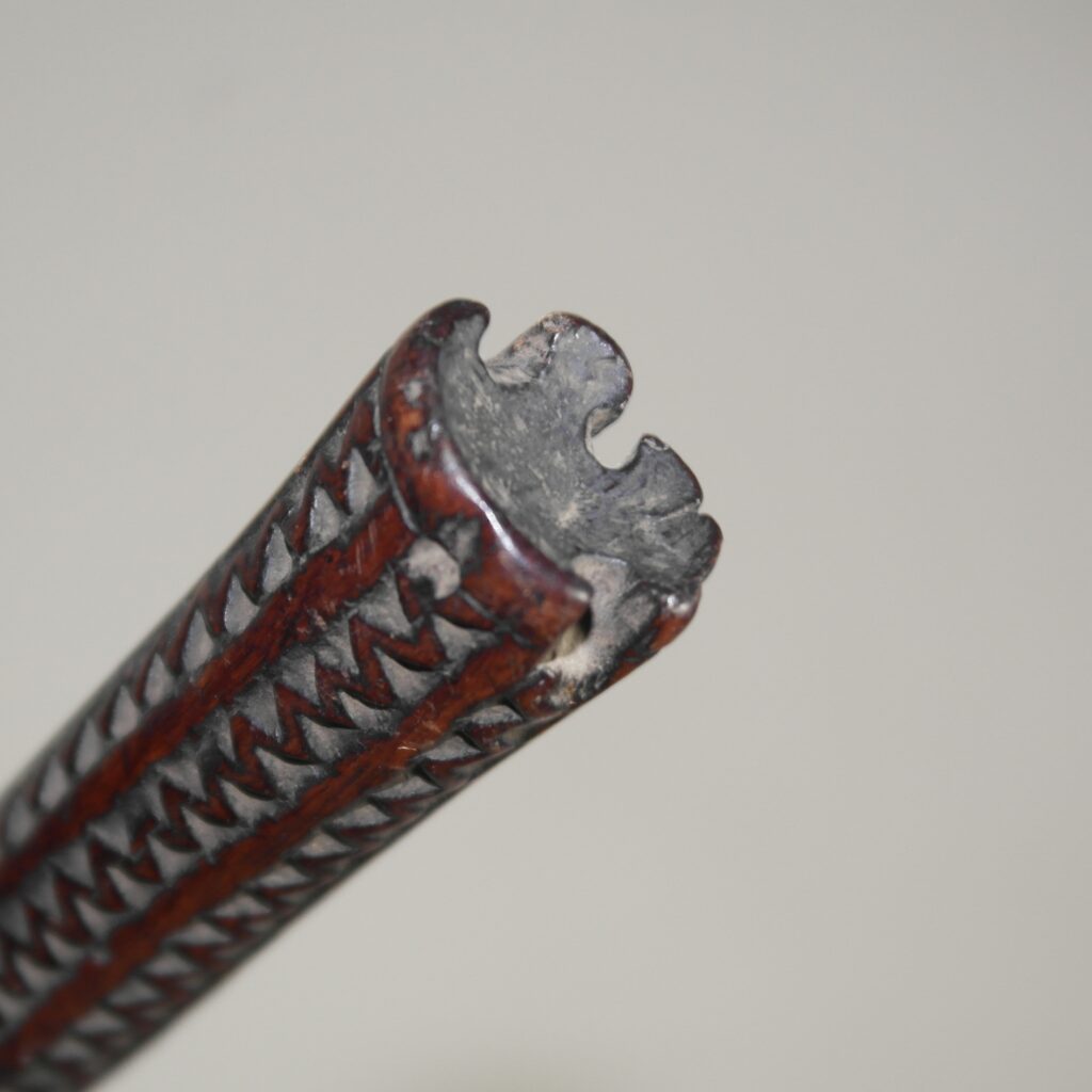 Early 19th century Fijian ula throwing club with a single human tooth inset and tavatava carving to the handle. This club has three suspension holes to the handle all of which have broken through.